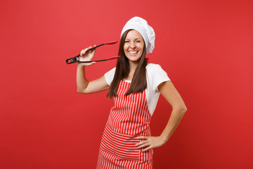 Female chef cook or baker in striped apron, white t-shirt toque chefs hat isolated on red wall...