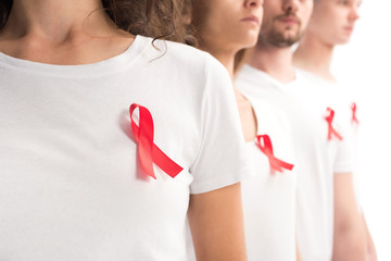 cropped image of people standing with red ribbons on white shirts isolated on white, world aids day...