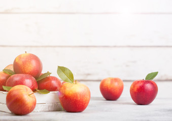 Healthy organic red apples in wooden box on white wooden background with sun light. Space for text