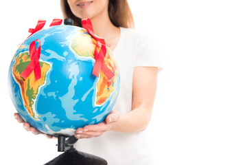 cropped image of woman holding globe with red ribbons isolated on white, world aids day concept