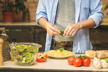 Man cooking healthy simple food at home in the kitchen sunny evening. Healthy food concept. Close-up.