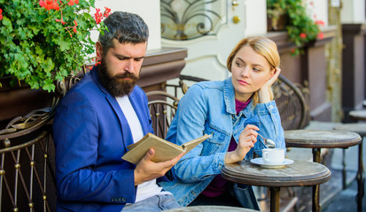 Man with beard and blonde woman on romantic date. Common interests. Couple in love sit cafe terrace. Romantic date. Couple flirting romantic date read book. Romance concept. Love and flirt