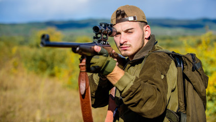 Man hunter aiming rifle nature background. Hunting skills and weapon equipment. Guy hunting nature...