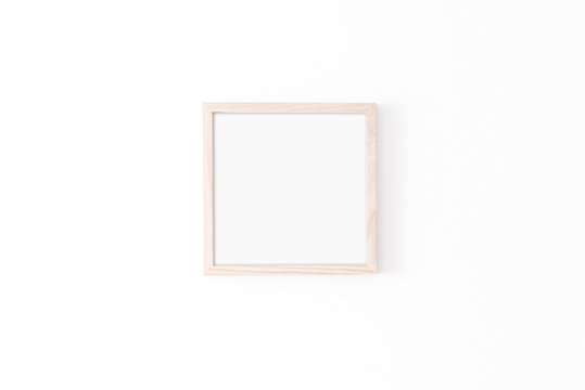 Wooden square frame mockup on white wall. Poster mockup. Clean, modern, minimal frame. Empty fra.me Indoor interior, show text or product