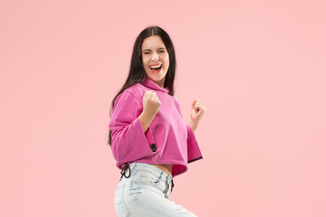 I won. Winning success happy woman celebrating being a winner. Dynamic image of caucasian female model on pink studio background. Victory, delight concept. Human facial emotions concept. Trendy colors