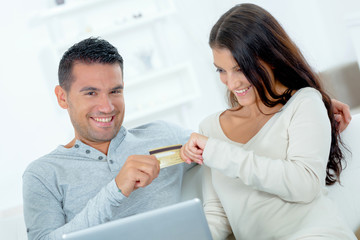 couple arguing playfully over credit card