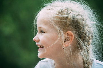 Enjoying new hair look. Little girl wear hair in long plaits. Happy little child with adorable...