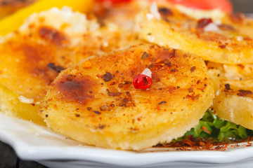 Homemade roasted potatoes with cheese and spices, closeup