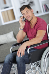 handsome man in wheelchair talking on his phone and smiles