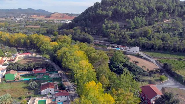 Aerial view on traveling of a landscape in autumn with river and yellow, orange and green trees. Segorbe, Castell&oacute;n. Spain