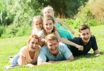 Fototapeta premium the large family lying on the grass in park.