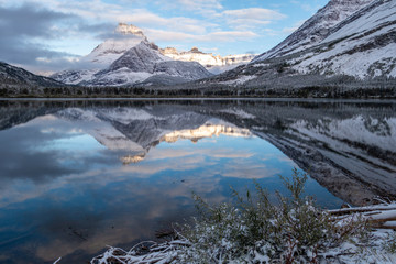 Mt Henkel reflected in Swiftcurrent Lake in the early dawn light after a snow storm. Glacier...