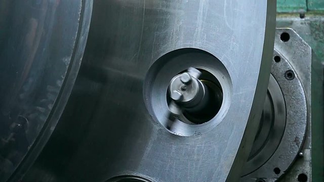 huge lathe closeup, large spindle lathe is rotating at an industrial plant. Shooting is made at a plant producing power steam turbines,Turning lathe in action,Industrial CNC drill machine