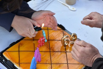 Prendiendo las velas de la tarta en el cumpleaños de tres amigos