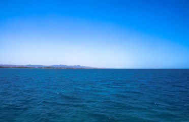 Beautiful blue sea surface with the sky. Oceanic deserted, lonely theme for background. Stock photo for tourist design