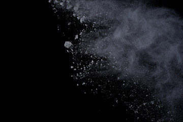 White powder explosion on black background. Dust splatted isolated. Paint Holi.