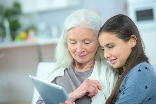 Grandmother And Grand Daughter Watching Tablet