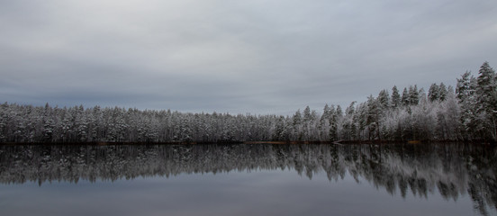 Fototapeta premium Autumn lake scenery with first snow flakes