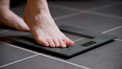 Male feet on glass scales, men's diet, body weight