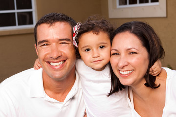 Happy Hispanic family laughing and smiling outside.