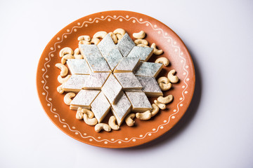 Kaju Katli is a Diamond shape Indian sweet made using cashew sugar and mava, served in a plate or...