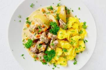 turkey stewed with apples and vegetables garnished with potato decorated with parsley