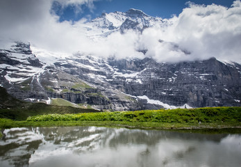 Mountains tower over reflective lake near Kleine Scheidegg
