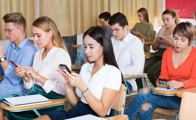 Students using smartphones on lecture