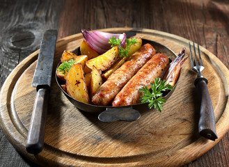 grilled, juicy sausages in a pan on a wooden background.rustic style.