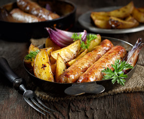 grilled, juicy sausages in a pan on a wooden background.rustic style.