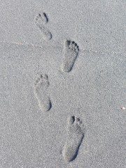 Footprints in the black sandy beach in Puerto de la Cruz in Teneriffe, Europe