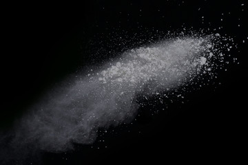 White powder explosion on black background. Dust splatted isolated. Paint Holi.