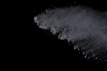 White powder explosion on black background. Dust splatted isolated. Paint Holi.