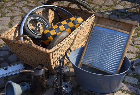Stand auf einem Flohmarkt mit Weidenkorb und Zinkwaschbrett in einem Waschbottich