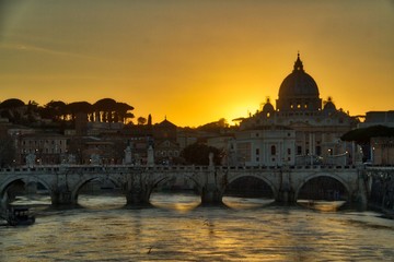 Naklejka premium View of the Vatican over the River Tiber with the sun setting behind St. Peter’s Basilica.