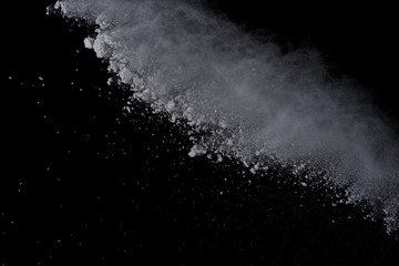 White powder explosion on black background. Dust splatted isolated. Paint Holi.