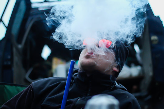 The man exhales the smoke. Smoking hookah Traveler Ukrainian Carpathian Mountains. Traveling