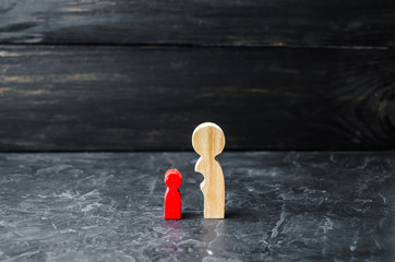 Wooden figures of mother and red child. The concept of maturation and self-reliance. Under the wing...