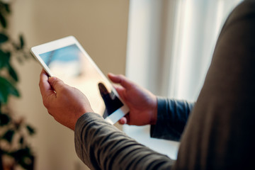 Senior male using a tablet for browsing the internet, happy and smiling