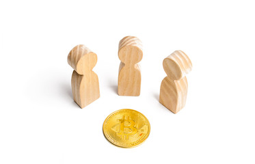 three figurines of people are standing around a bitcoin coin on a white background. cryptocurrency...