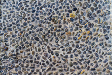 A background image of stone pebbles in concrete.