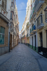 Fototapeta na wymiar A medieval street, empty of crowds, in the city of Cadiz, Spain.