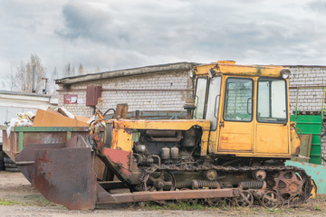 old rusty yellow abandoned tractor with bucket