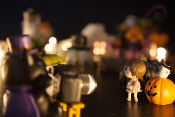 dark wizard cat using camera to take girl photo with pumpkins and ghost in front of Halloween festival party house. Festive Celebration, Holidays, Fun, Halloween toy and doll decoration theme concept.
