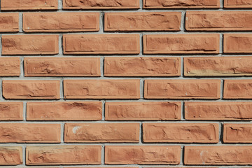 Fototapeta premium Wall of new uneven brick on a sunny day