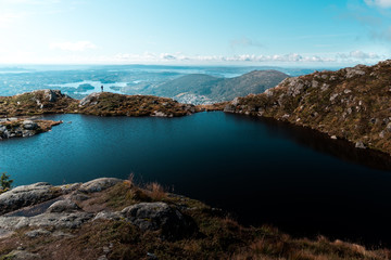 Fototapeta na wymiar Scenic view of Ulriken Peak in Bergen Norway with Pond on Mountain with Human Figure Framed by Landscape