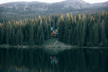 A house surrounded by trees and a lake 