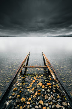 Rails en m&eacute;tal rouill&eacute;s entrant dans l'eau