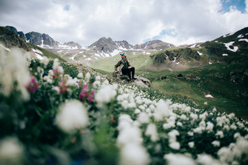 A man sitting on a rock in a field 