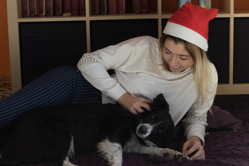 happy young pretty girl with her dog at christmas